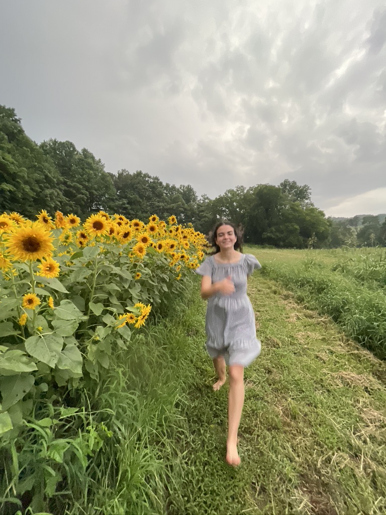 happy girl running barefoot in summer sunny sunflower field